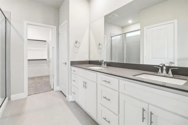 a bathroom with a granite countertop sink a mirror a shower and vanity