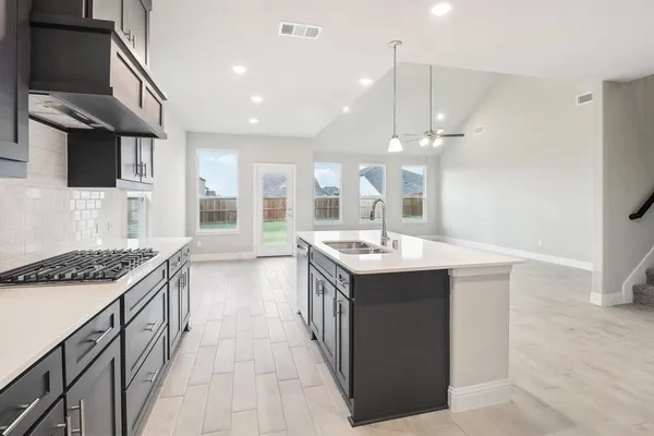 a kitchen with a sink stove and cabinets