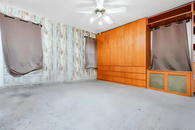 a view of a room with wooden walls and a window