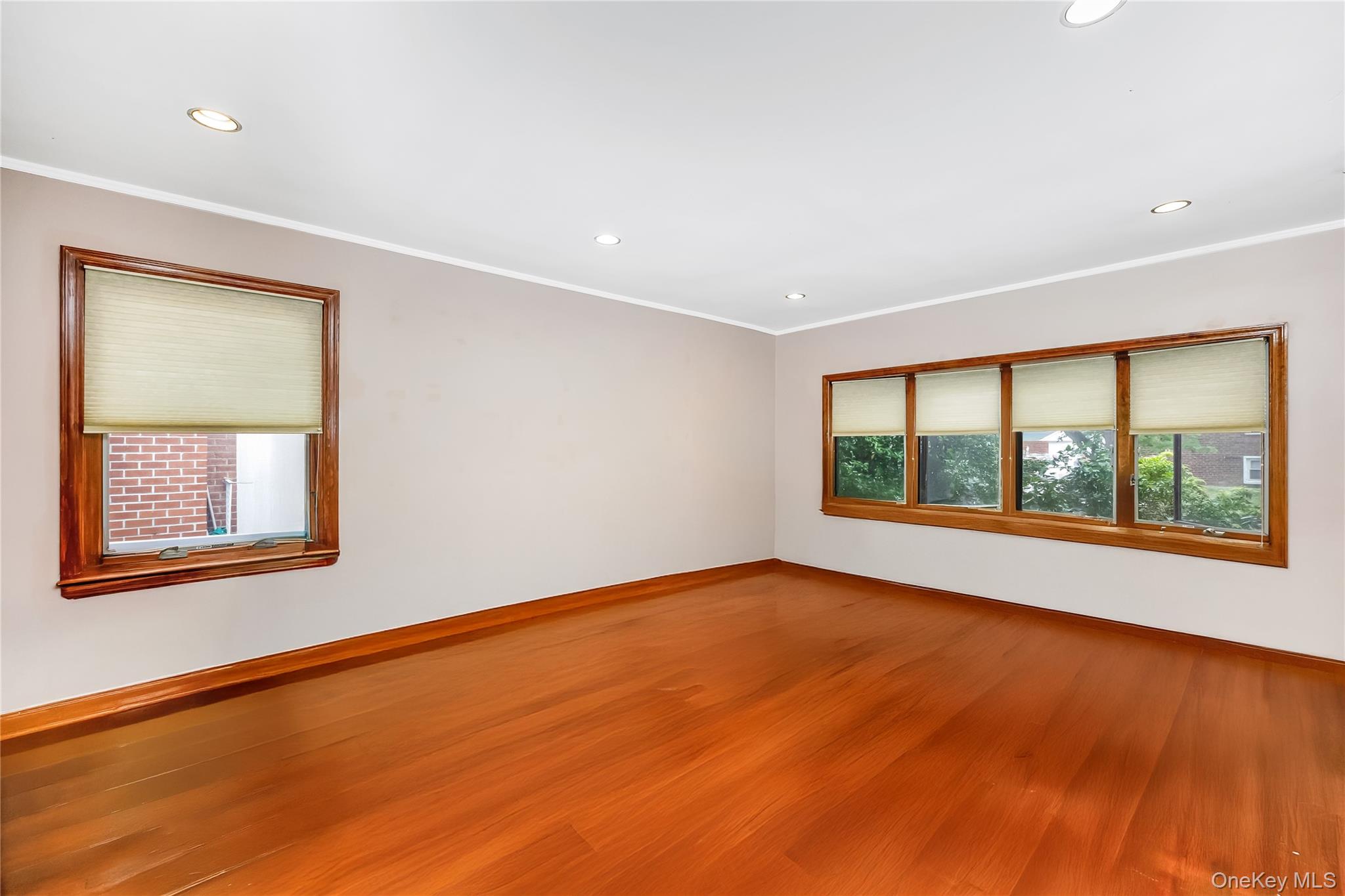 65-32 170th Street Queens, NY 11365 - Photo 3 of 24 a view of an empty room with a window and wooden floor