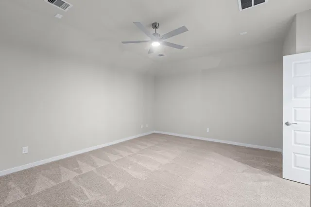 an empty room with an entryway and fan