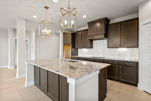 a kitchen with stainless steel appliances granite countertop a sink a oven a refrigerator and wooden cabinets