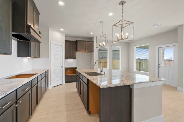 a large kitchen with kitchen island granite countertop a large center island and a sink