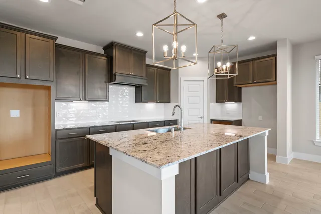 a kitchen with stainless steel appliances granite countertop a sink a refrigerator and a stove