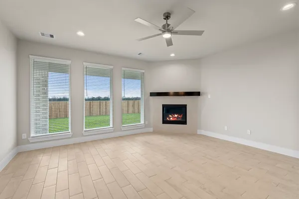 a view of an empty room with a fireplace and a window
