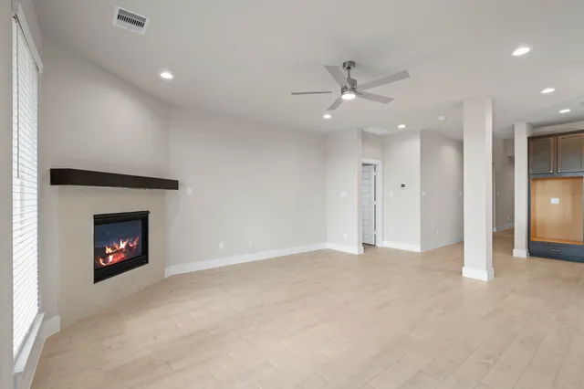 an empty room with a fireplace and fan