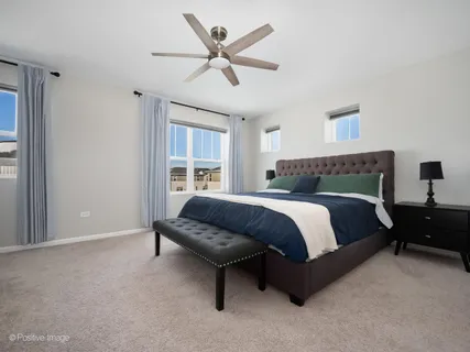 a bedroom with a bed a couch and a ceiling fan