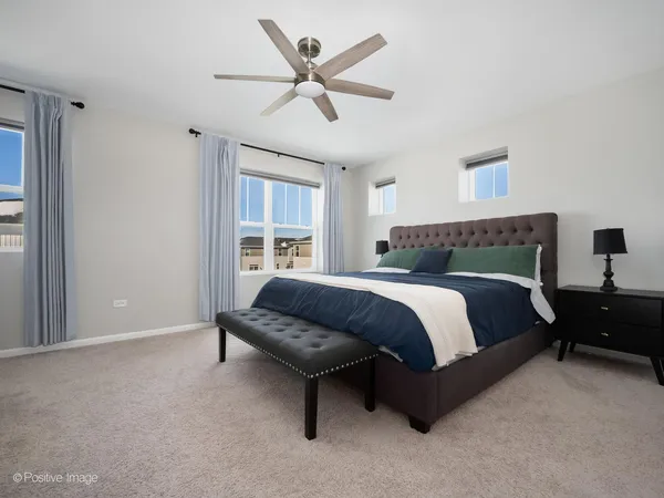 a bedroom with a bed a couch and a ceiling fan