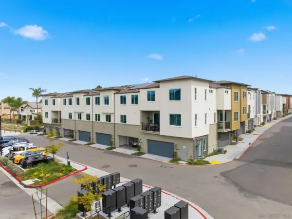 a view of a large white building with a yard