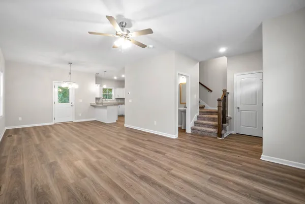 a view of a kitchen with wooden floor and a ceiling fan