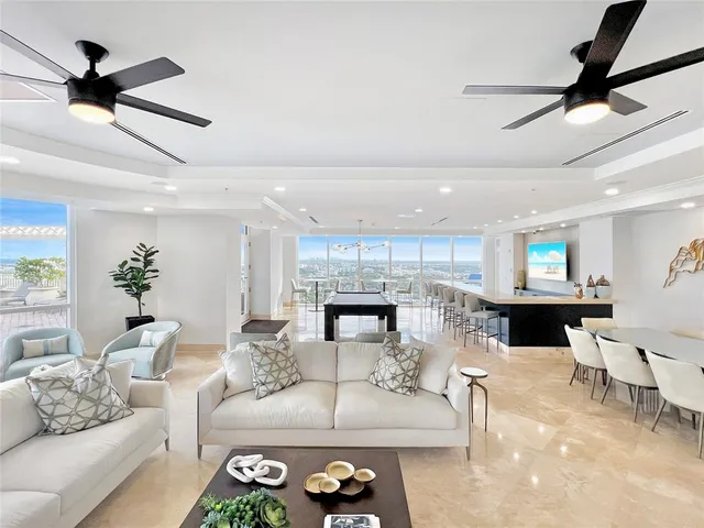 a large room with stainless steel appliances kitchen island a stove and a table