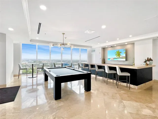 a living room with stainless steel appliances furniture and a kitchen view