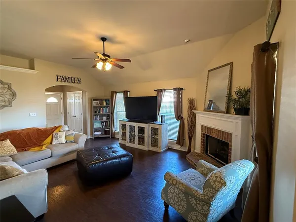 a living room with furniture a flat screen tv and a fireplace