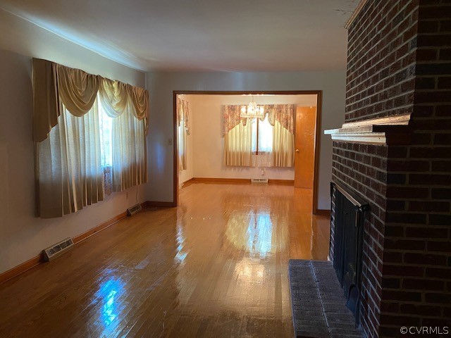 6430 Plank Road Kenbridge, VA 23944 - Photo 17 of 34 a hallway with wooden floor windows and a fireplace