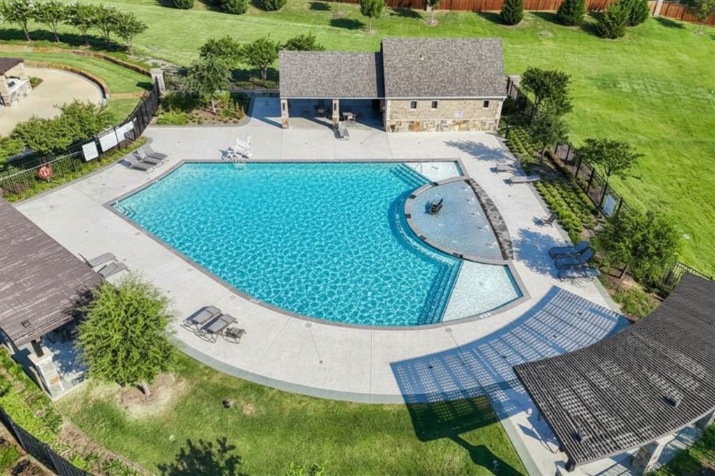 11732 Wulstone Road Fort Worth, TX 76052 - Photo 30 of 34 Spacious community pool area featuring a large swimming pool, integrated splash pad, surrounding concrete decking, two covered pergolas, and a stone-clad amenity building
