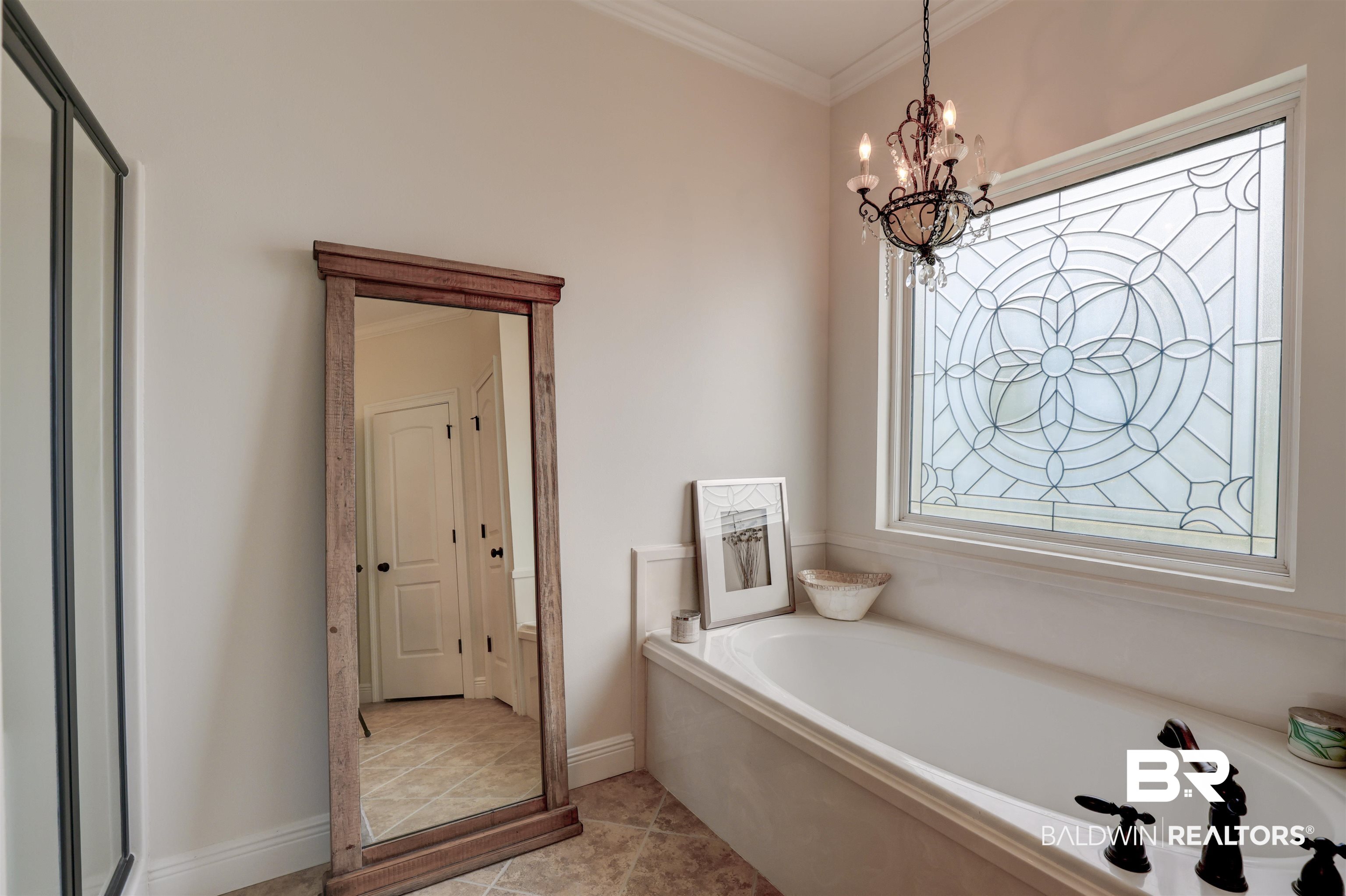 5565 Dawes Lane Theodore, AL 36582 - Photo 18 of 38 Bathroom featuring plus walk in shower, ornamental molding, an inviting chandelier, and tile patterned floors