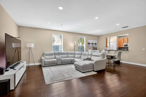 a living room with furniture flat screen tv and wooden floor