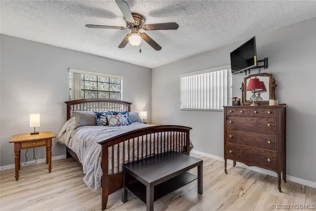 a bedroom with a bed and a flat tv screen on dresser