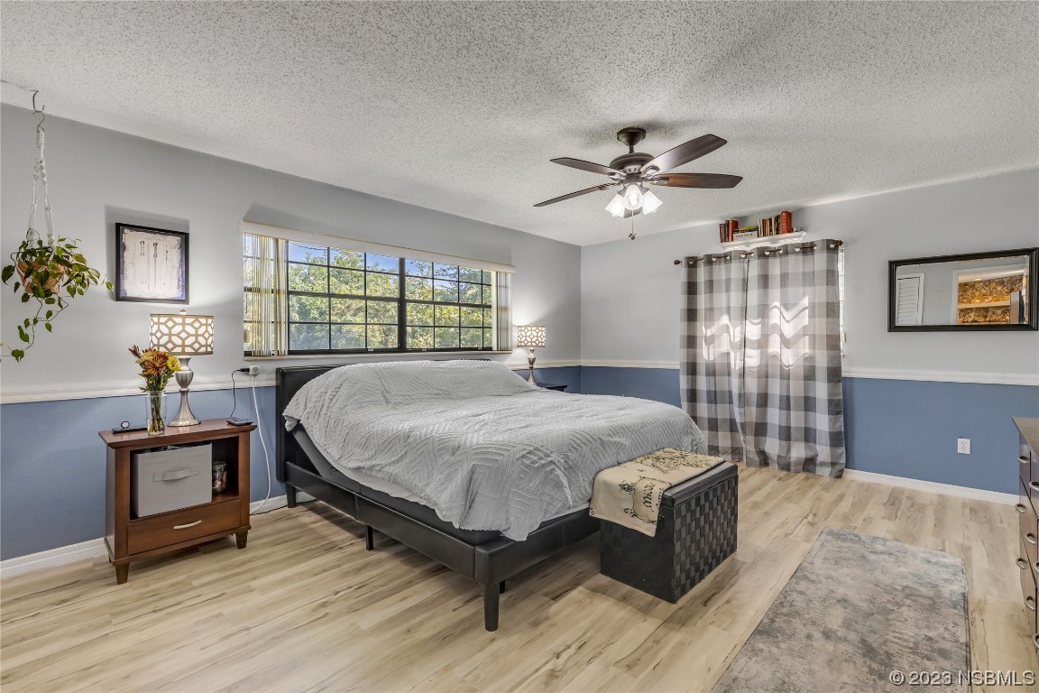 131 Silver Circle Edgewater, FL 32141 - Photo 19 of 30 a spacious bedroom with a bed and a chandelier