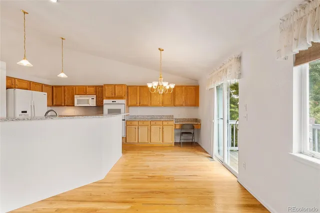 a view of a kitchen with kitchen island a counter top space a sink and appliances