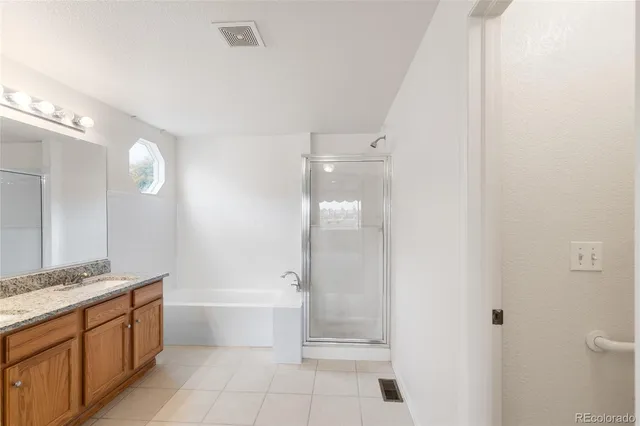 a bathroom with a granite countertop sink a toilet and shower