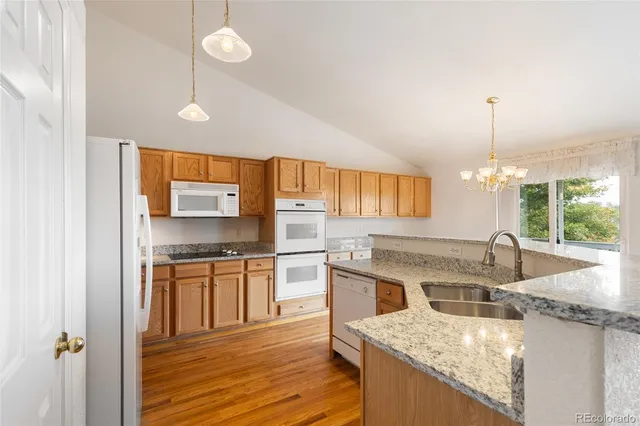 a kitchen with stainless steel appliances granite countertop sink stove top oven and refrigerator