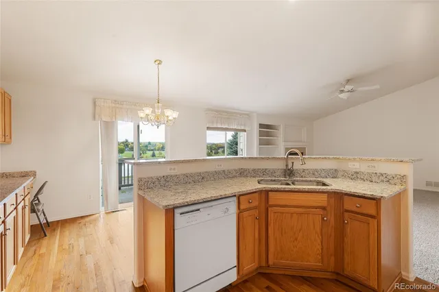 a kitchen with kitchen island granite countertop a sink cabinets and wooden floor