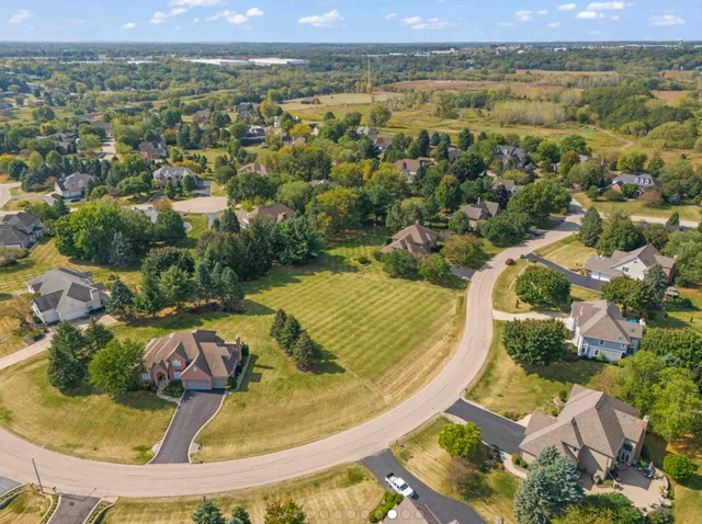 an aerial view of a house with a swimming pool and lake view