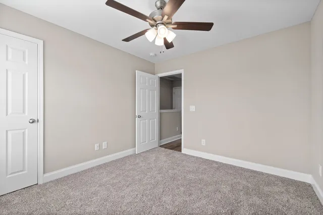 an empty room with closet and a chandelier fan