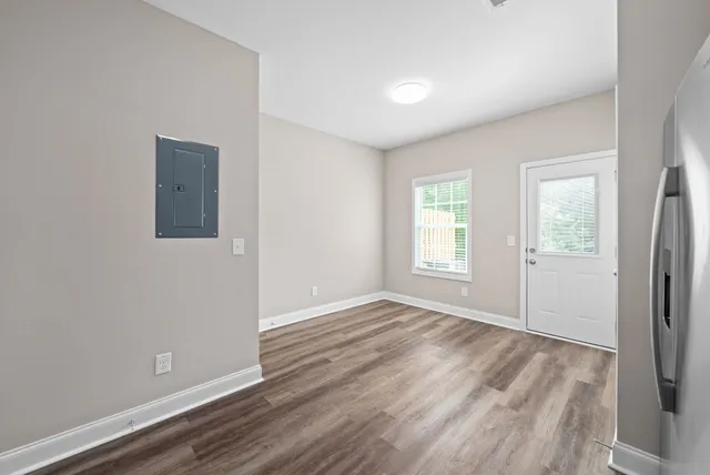 an empty room with wooden floor and windows