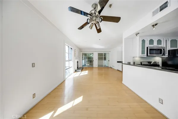 a large white kitchen with granite countertop a stove top oven a sink and a window