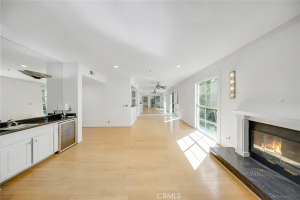 a view of an empty room with kitchen and a window