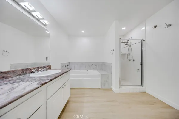 a spacious bathroom with a granite countertop sink mirror and bathtub