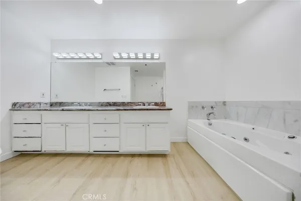 a spacious bathroom with a granite countertop sink a mirror and shower