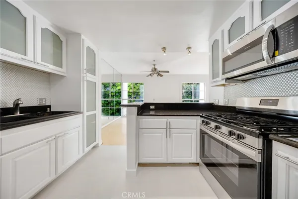 a kitchen with stainless steel appliances granite countertop a stove and a sink