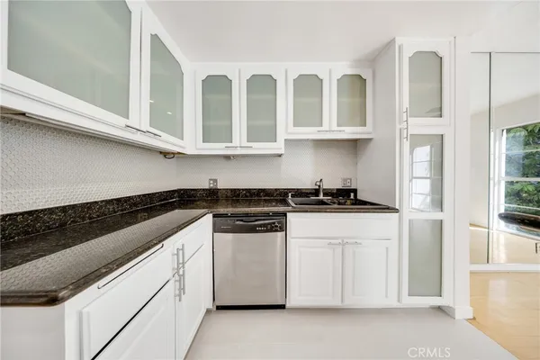 a kitchen with stainless steel appliances granite countertop white cabinets and a stove