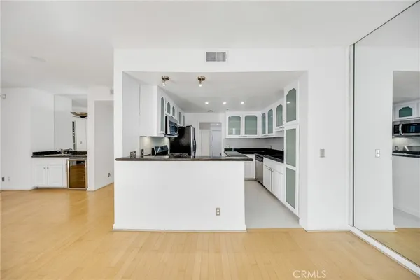 a large white kitchen with kitchen island a sink a stove and a refrigerator