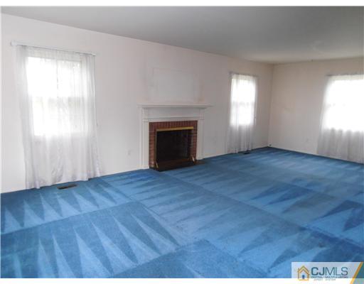 18 Edgewood Road Old Bridge, NJ 07747 - Photo 4 of 21 an empty room with wooden floor fireplace and windows