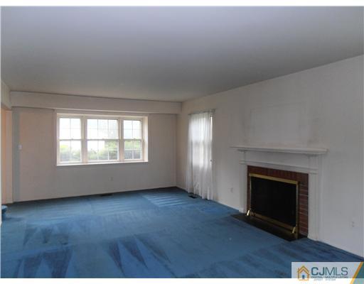 18 Edgewood Road Old Bridge, NJ 07747 - Photo 5 of 21 an empty room with wooden floor fireplace and windows
