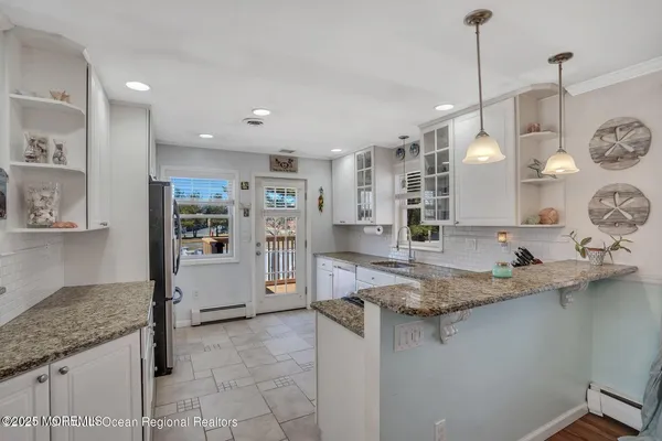 a kitchen with stainless steel appliances granite countertop a sink a refrigerator and a granite counter tops