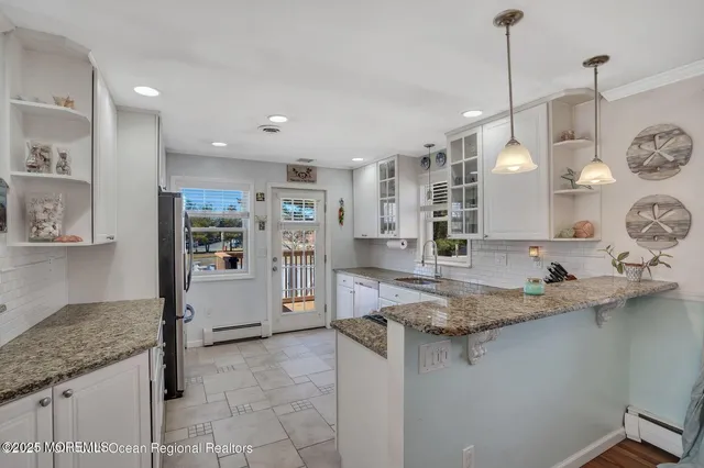 a kitchen with stainless steel appliances granite countertop a sink a refrigerator and a granite counter tops