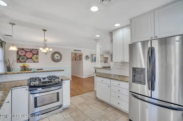 a kitchen with stainless steel appliances granite countertop a stove and a refrigerator
