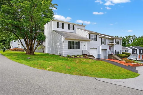 a front view of a house with a yard and trees
