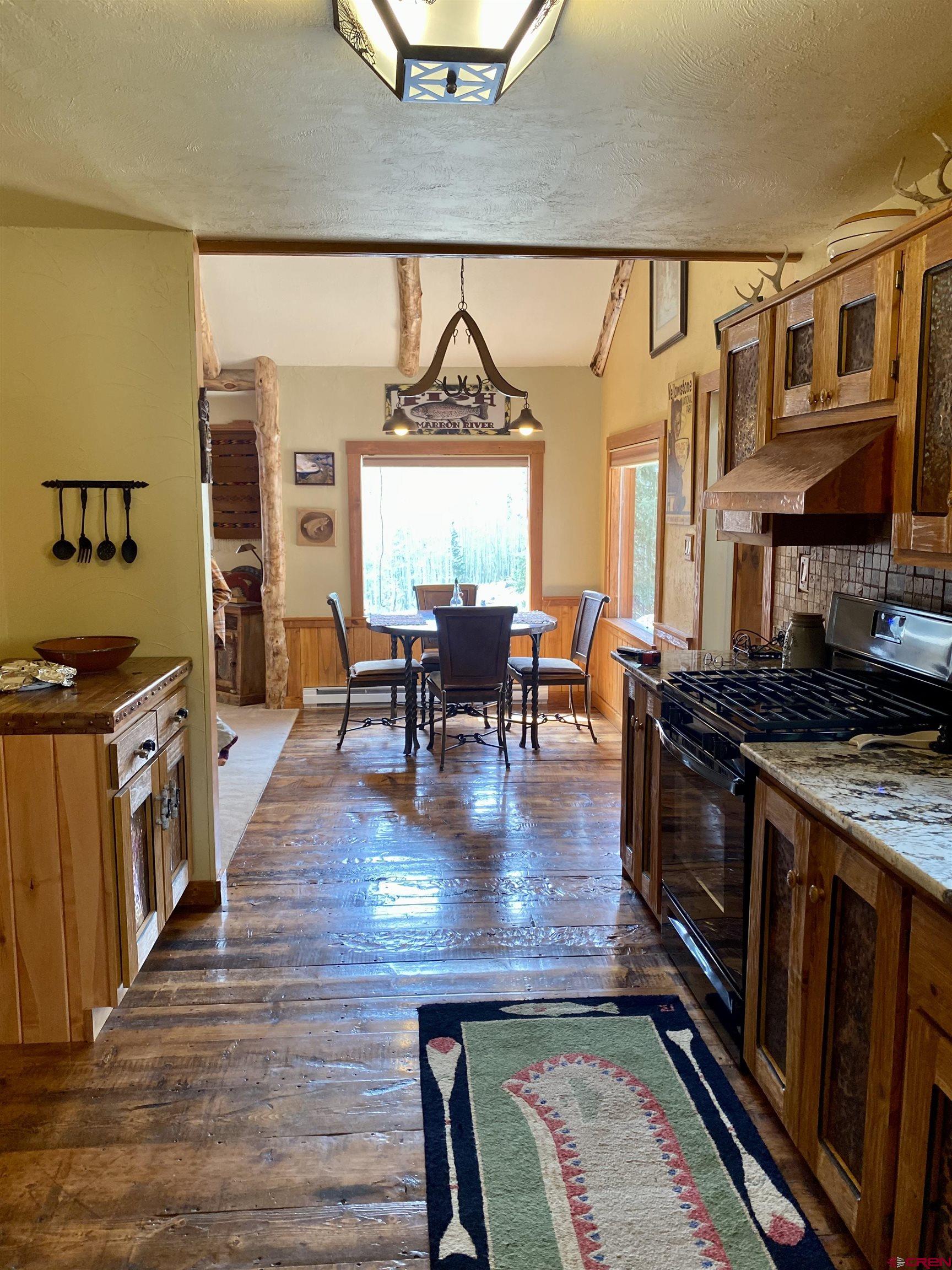 480 Bear Trail Montrose, CO 81403 - Photo 10 of 35 a kitchen with stainless steel appliances granite countertop a stove and a view of living room
