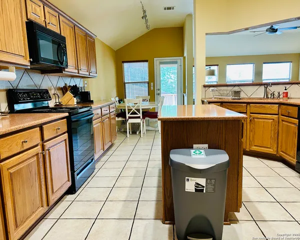 a kitchen with stainless steel appliances granite countertop a refrigerator a stove and a sink