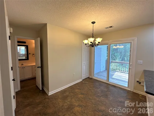 a view of a room with a chandelier fan and windows