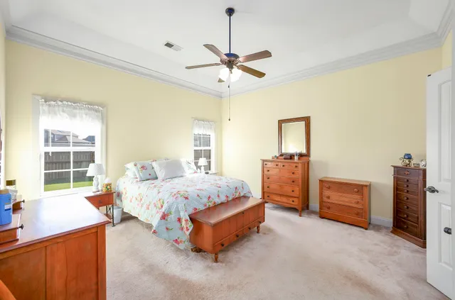 a spacious bedroom with a bed and a chandelier