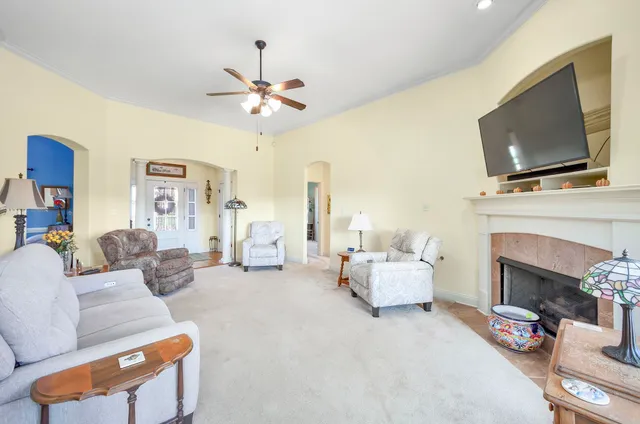 a living room with furniture a flat screen tv and a fireplace