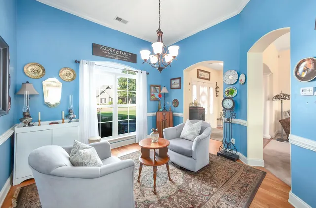 a living room with furniture a chandelier and a large window