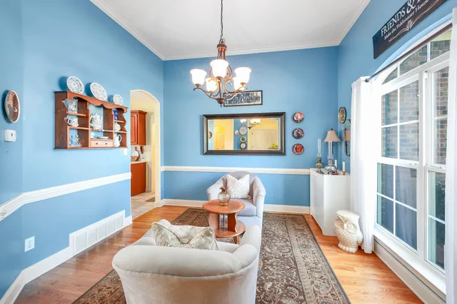 a living room with furniture and a chandelier